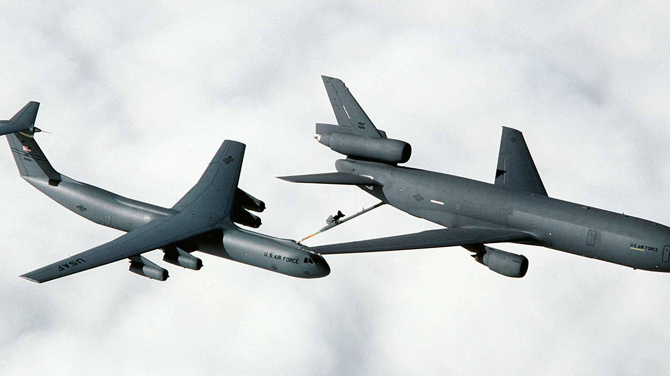 A 79th Air Refueling Squadron (79th AREFS) KC-10A Extender aircraft refuels a 7th Airlift Squadron (7th AS) C-141B Starlifter aircraft as the two planes fly above the clouds over northern California. The KC-10 Extender is an air-to-air tanker aircraft in service with the United States Air Force derived from the civilian DC-10-30 airliner. The KC-10 was the second consecutive McDonnell Douglas transport aircraft to be selected by the US Air Force following the C-9 Nightingale. Conversion to the KC-10 involved only minor modifications to the DC-10-30, the largest of which was the addition of a boom control station in the rear of the fuselage and extra fuel tanks under the main deck. First deliveries to the Strategic Air Command (then in control of AAR assets) commenced in 1981. The USAF Strategic Air Command had KC-10 Extenders in service from 1981 through 1991, when they were re-assigned to the Air Mobility Command. [U.S. Air Force Photo by Staff Sgt. John McDowell]